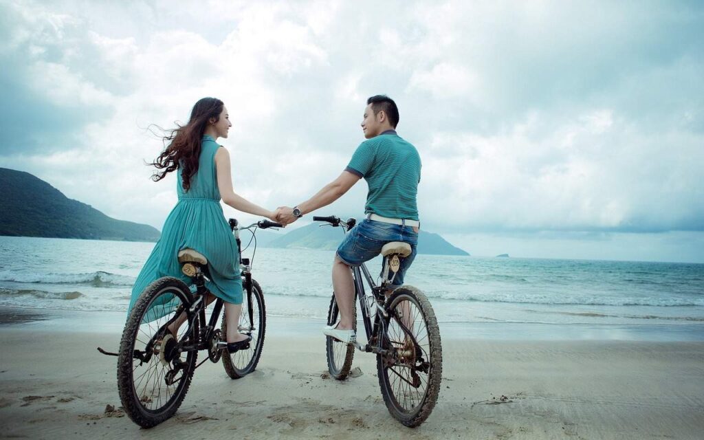 A couple cycling on the beach