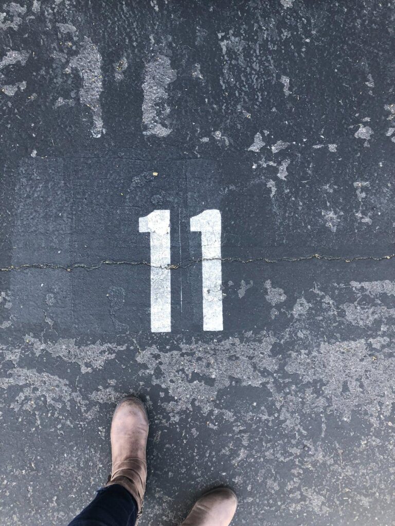 Person standing next to number 11 written on the ground
