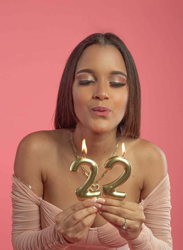 A woman celebrating her 22nd birthday blowing candles
