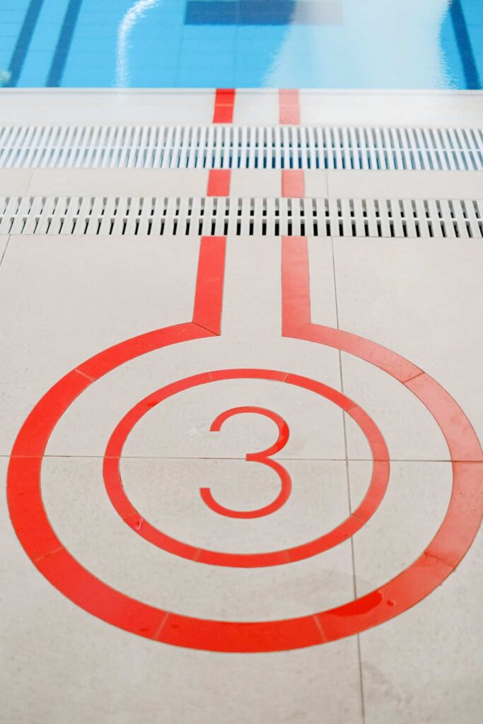 Number 3 written on the floor next to a swimming pool