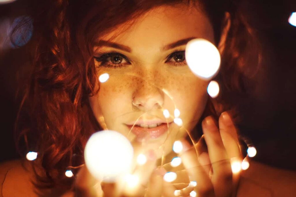 Young woman holding fairy lights