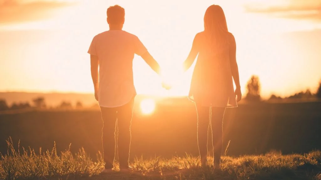 Couple holding hands by sunset