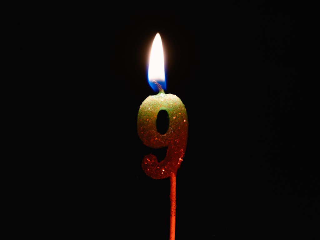 Burning Number Nine Candle on a Black Background