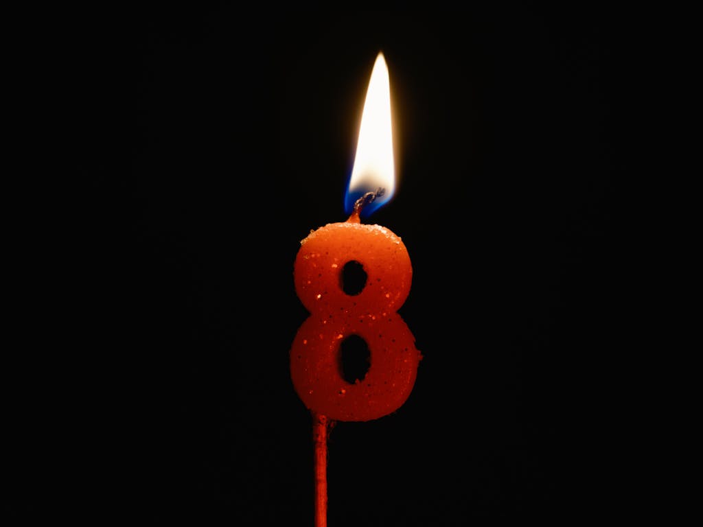 Close-up Photo of a Lighted Number Eight Candle